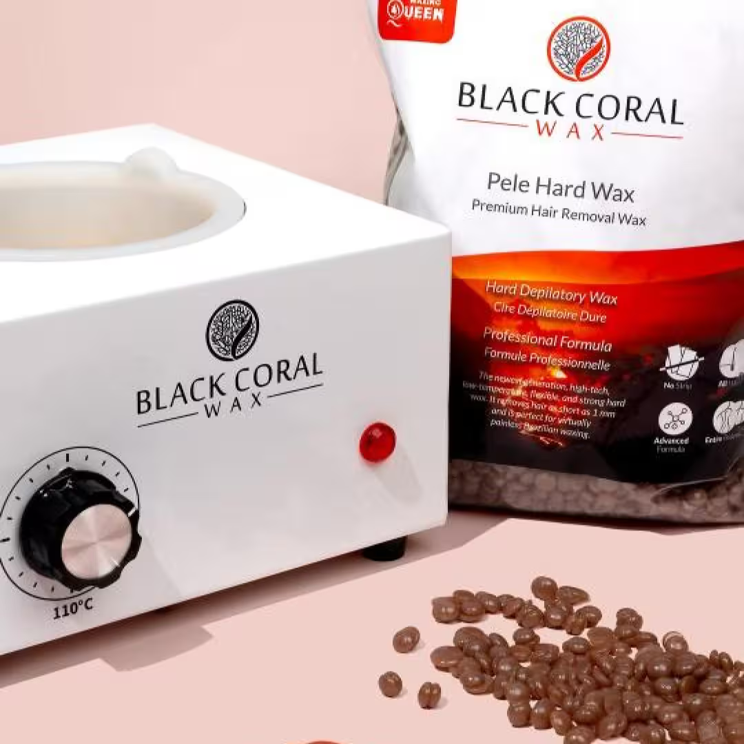 A bag labeled "Pele Hard Wax Beads" by Black Coral Wax USA stands behind a white wax warmer set to 110°C, while hard wax beads are scattered on a pink surface—ideal for removing coarse hair.