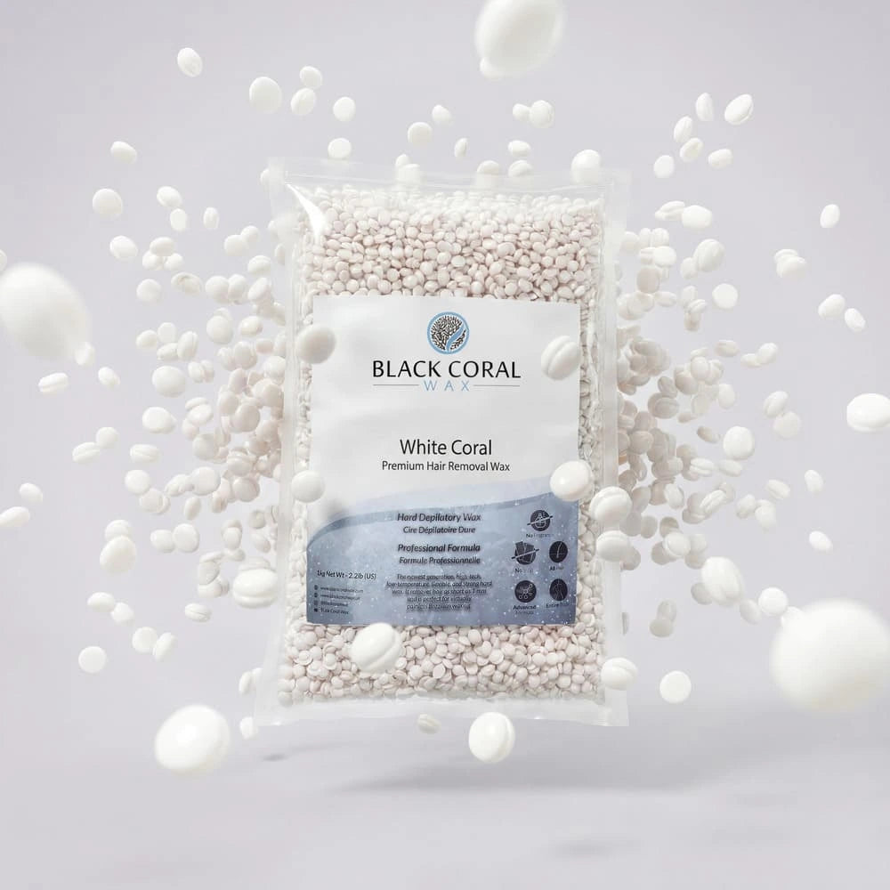 A clear bag of White Coral Wax by Black Coral Wax USA for sensitive skin is surrounded by loose hard wax beads floating against a light gray background.