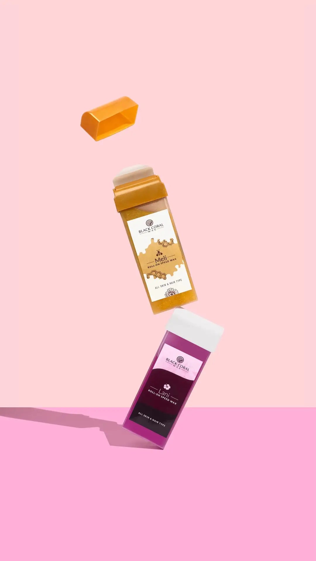 Two Meli Roll-On SpeedWax sticks by Black Coral Wax USA float mid-air on a pink background—one orange and open with cap above, the other purple and closed. Both promise lasting smoothness inspired by gentle waxing.