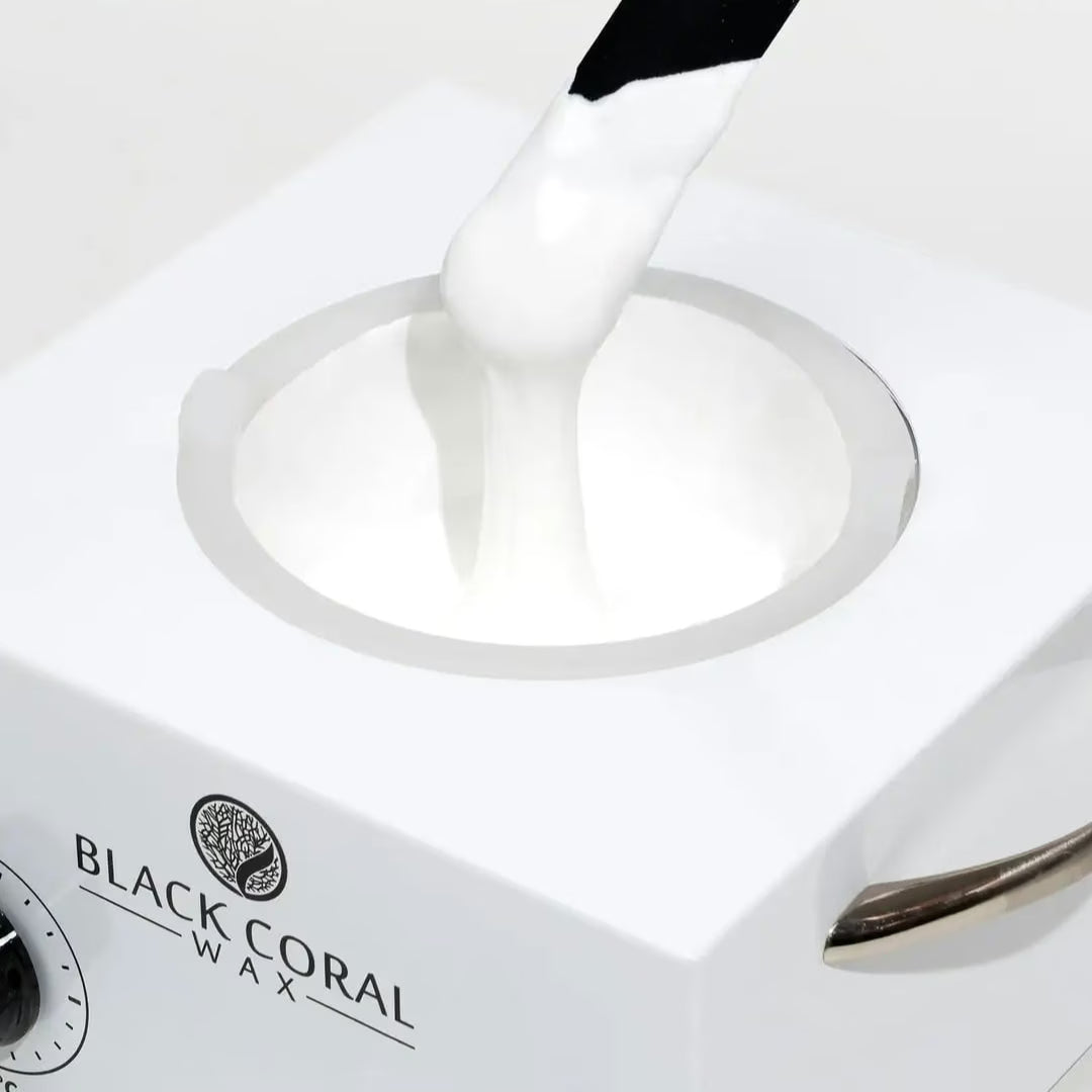 White wax being applied to a heating element with 'Black Coral Wax' branding.