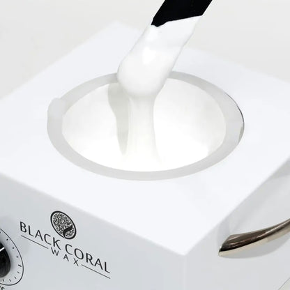 White wax being applied to a heating element with 'Black Coral Wax' branding.