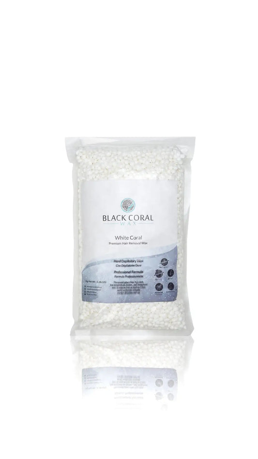 A clear plastic bag of White Coral Wax by Black Coral Wax USA, premium hard wax beads for sensitive skin, with a white and blue label, stands upright on a white background with a subtle reflection beneath.