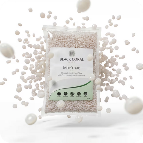 A bag of Mae Mae Hard Wax (Free Gift) from Black Coral Wax USA, featuring coconut oil and shea butter for hypoallergenic care, is surrounded by loose white wax beads floating in mid-air. The packaging is clear with white and green labeling.