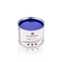 A tin of Black Coral Wax USAs Maui Lavender Soft Wax, enriched with lavender essential oil, boasts a deep purple color and creamy texture. Its label features a lavender graphic with the product name, resting on a white reflective surface.