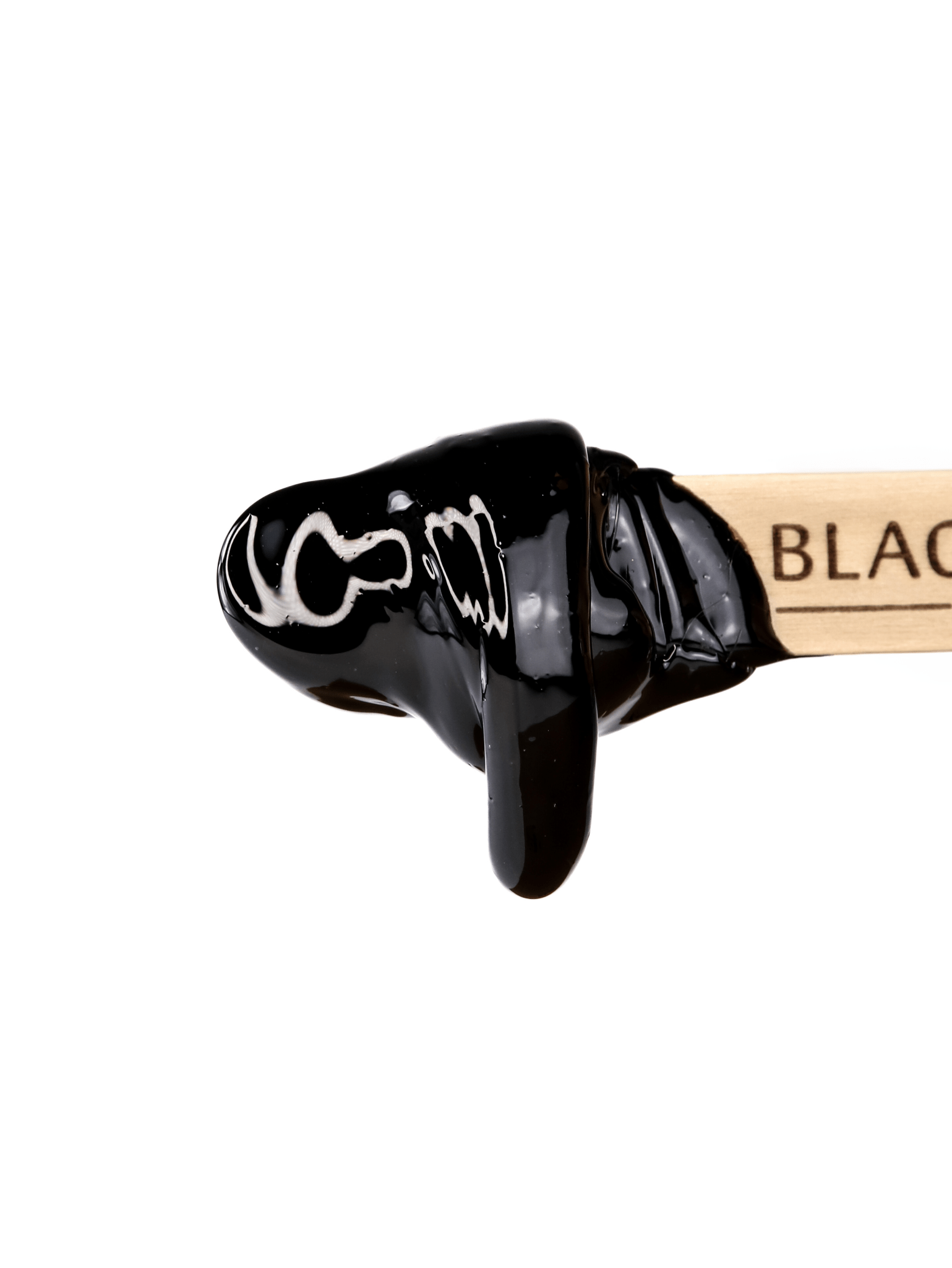 A wooden stick with BLACK partially visible is dipped in Black Coral Hard Wax by Black Coral Wax USA, showcasing a glossy, smooth finish. The stripless wax promises long-lasting hair removal and stands out against a white background.